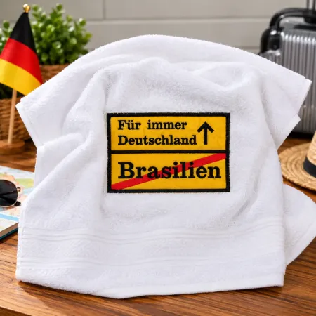 Weißes Handtuch 50x100 cm mit gelbem Ortsschild, gesticktem Schriftzug Für immer Deutschland und rot durchgestrichenem Brasilien