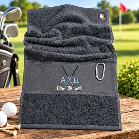 Dunkelgraues Golfhandtuch mit Initialen A H in Hellblau und Golfmotiv bestickt