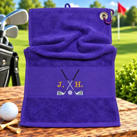Dunkellila Golfhandtuch mit Initialen J. H. in Gold bestickt