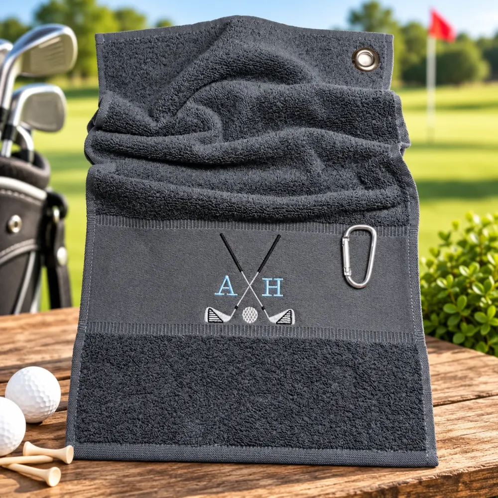 Dunkelgraues Golfhandtuch mit Initialen A H in Hellblau und Golfmotiv bestickt