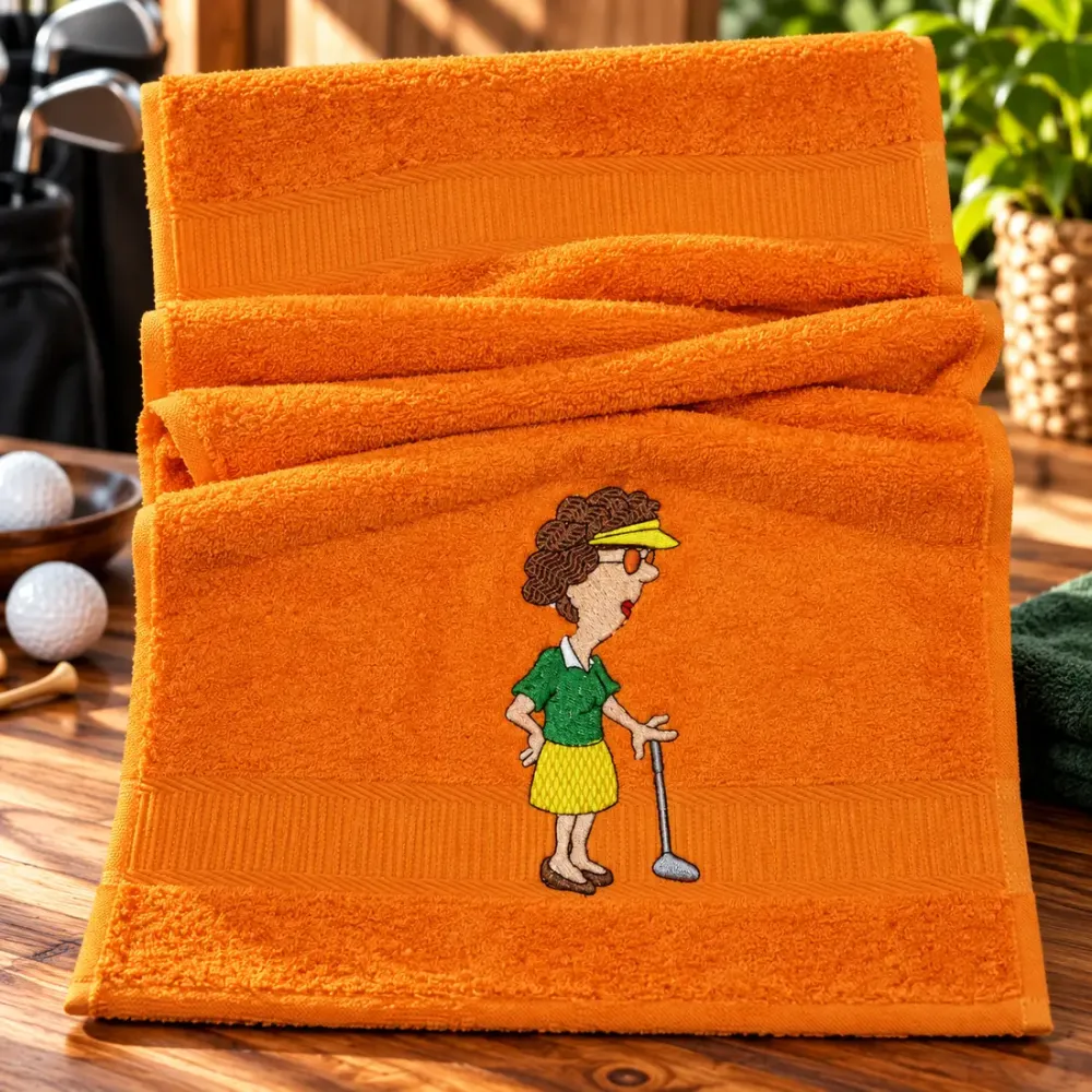 Oranges Gästehandtuch 30x50 cm aus Baumwolle mit lustiger gestickter Golfspielerin im grünen Oberteil und gelben Rock